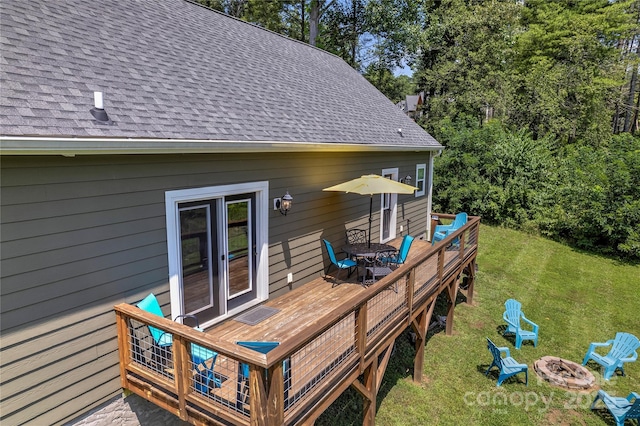 wooden terrace featuring a fire pit and a yard