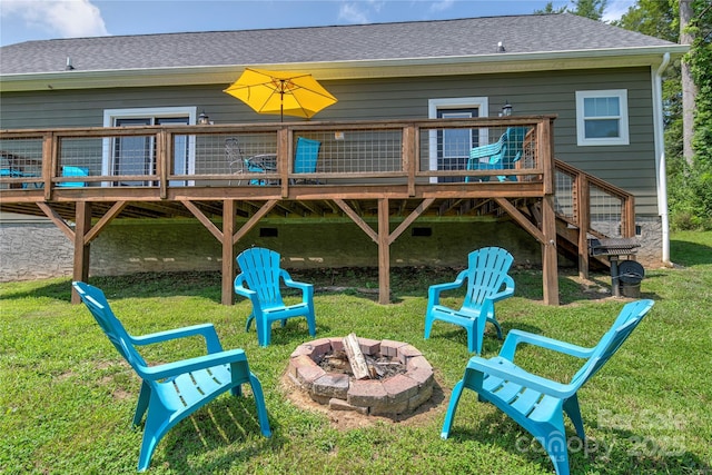 view of play area featuring a fire pit, a yard, stairway, and a wooden deck