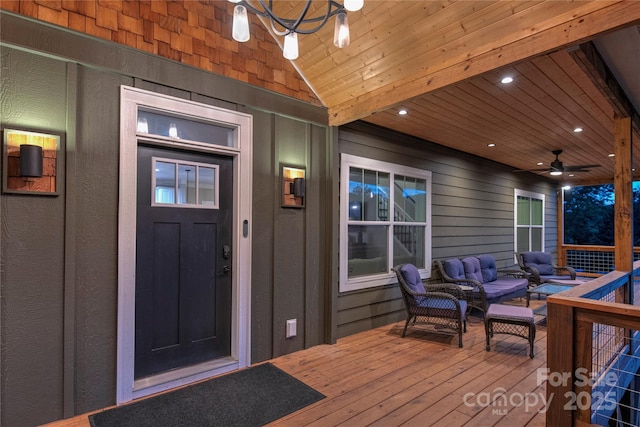 doorway to property with board and batten siding, ceiling fan, and an outdoor living space