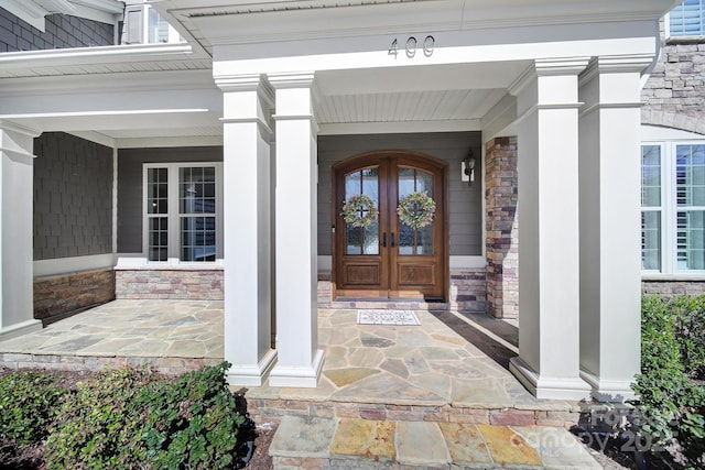 doorway to property with stone siding and french doors