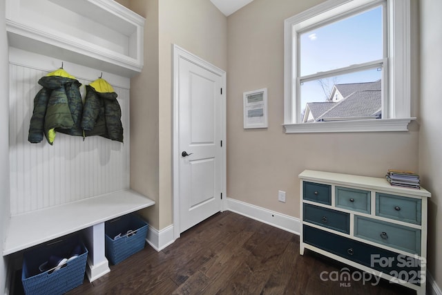 mudroom featuring dark wood-type flooring and baseboards