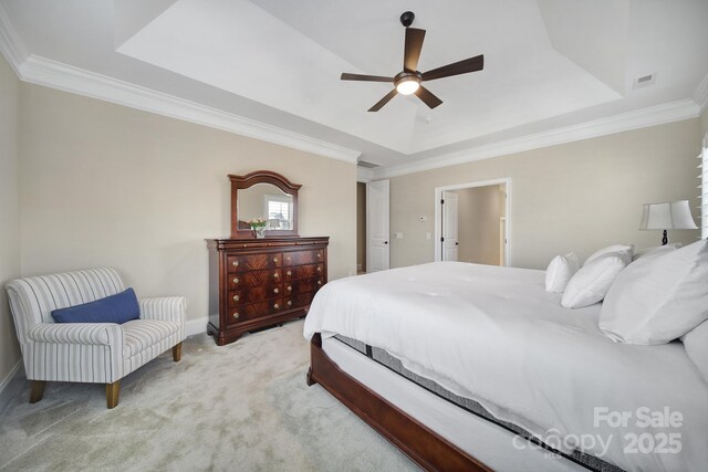 bedroom with visible vents, a tray ceiling, carpet, and ornamental molding