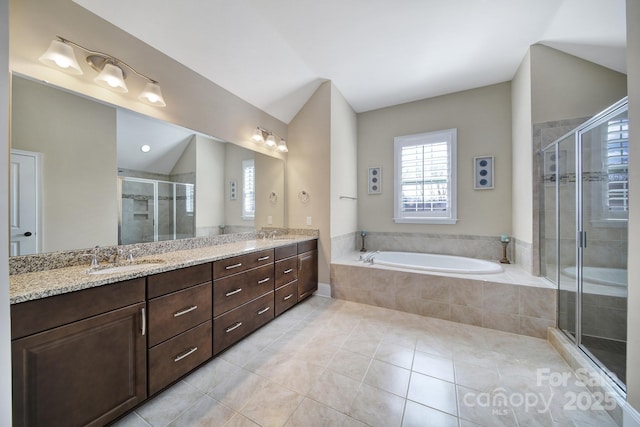 full bathroom featuring a shower stall, a bath, double vanity, and a sink