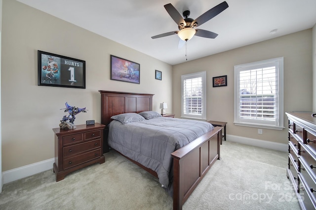 bedroom featuring light colored carpet, baseboards, and ceiling fan