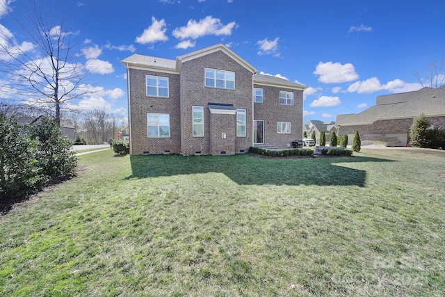 back of property with crawl space, brick siding, and a yard