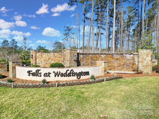 community / neighborhood sign featuring a lawn