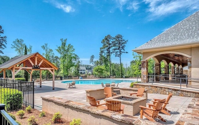 community pool featuring a gazebo, a fire pit, fence, and a patio