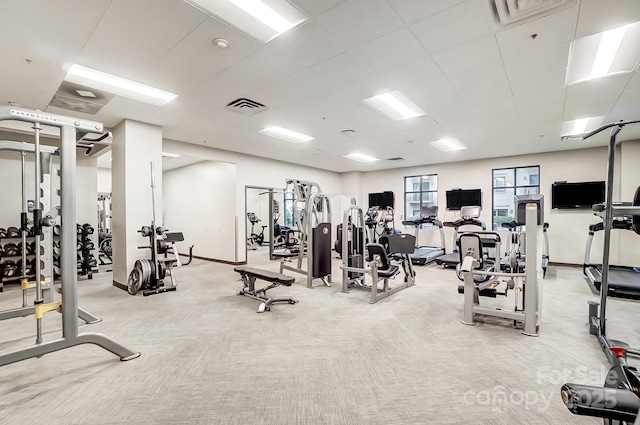 workout area featuring a paneled ceiling and light colored carpet