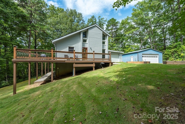 back of property featuring a garage, a yard, an outbuilding, and a deck