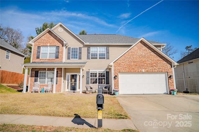 traditional home with a porch, a garage, brick siding, driveway, and a front yard