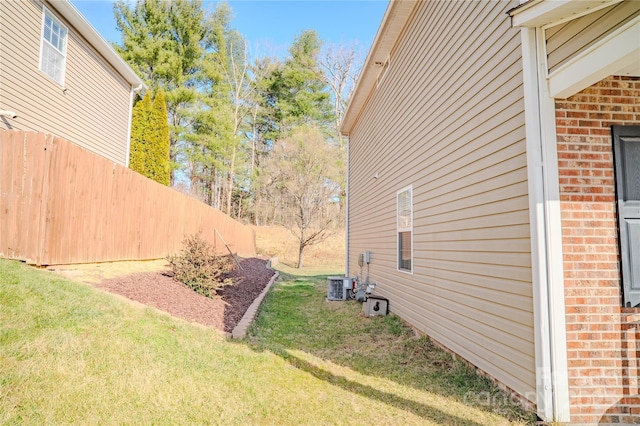 view of yard with fence and central AC