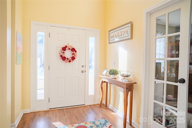 entryway featuring baseboards and wood finished floors