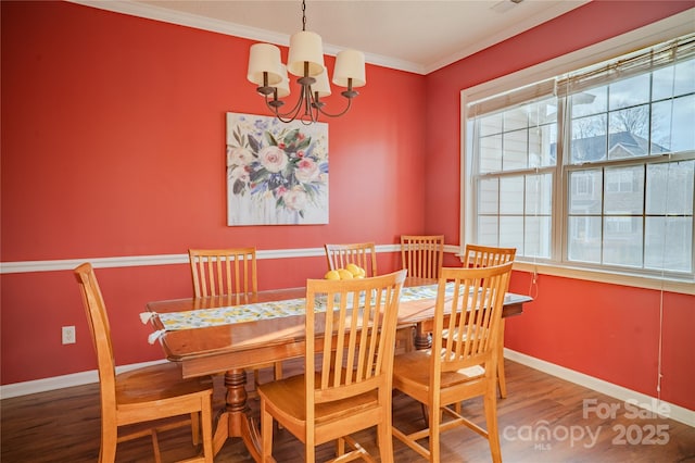 dining area with crown molding, baseboards, a chandelier, and wood finished floors