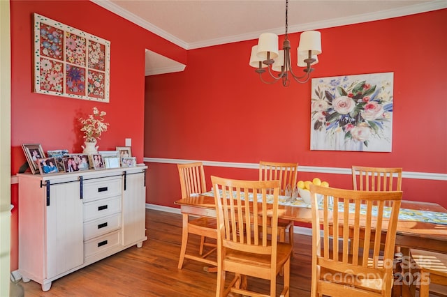 dining area featuring a notable chandelier, crown molding, baseboards, and wood finished floors