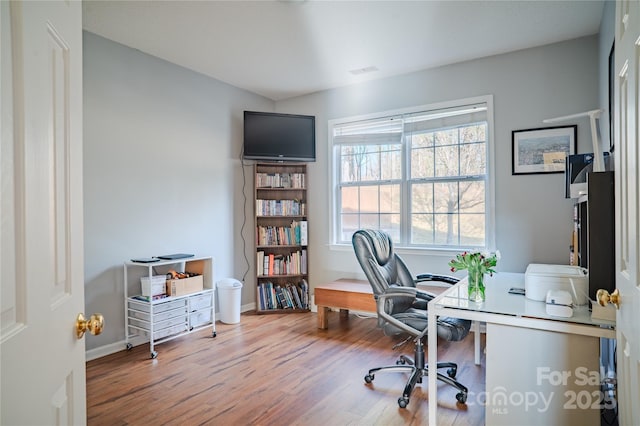 office space with wood finished floors, visible vents, and baseboards