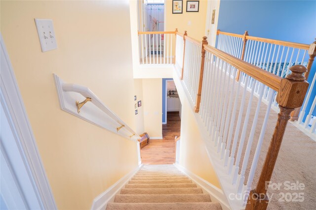 stairway with wood finished floors and baseboards