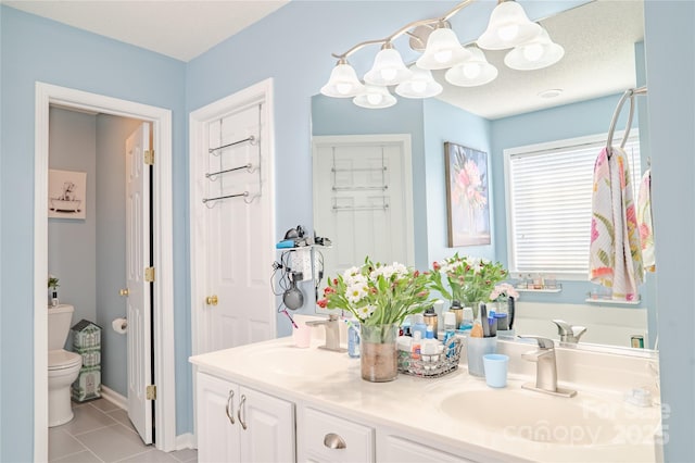 full bathroom with double vanity, toilet, tile patterned flooring, a textured ceiling, and a sink