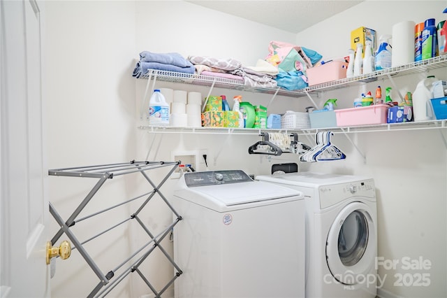 clothes washing area featuring laundry area and washer and clothes dryer