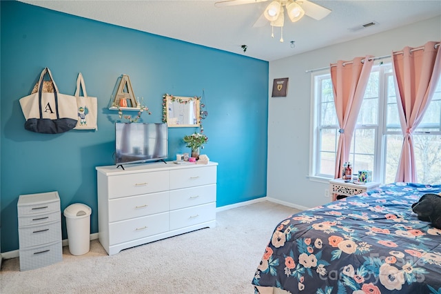 carpeted bedroom with a ceiling fan, visible vents, and baseboards