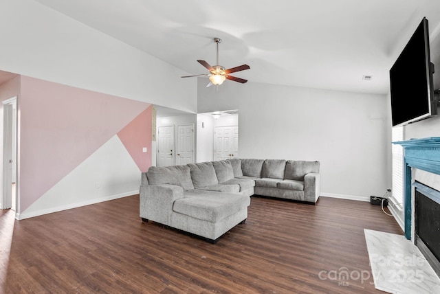 living room featuring dark hardwood / wood-style floors, ceiling fan, lofted ceiling, and a premium fireplace