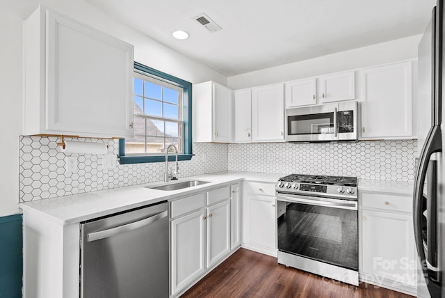 kitchen featuring white cabinetry, stainless steel appliances, sink, and backsplash