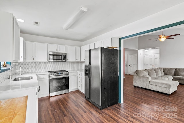 kitchen with stainless steel appliances, dark hardwood / wood-style floors, sink, and white cabinets