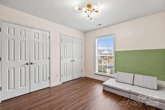 unfurnished room with dark wood-type flooring and a notable chandelier