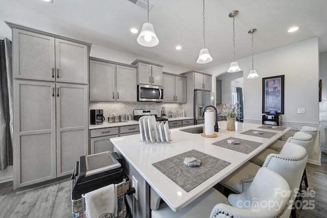 5239 Admirals Lndg, Lancaster, SC 29720 - kitchen with appliances with stainless steel finishes, hanging light fixtures, gray cabinetry, a breakfast bar area, and sink