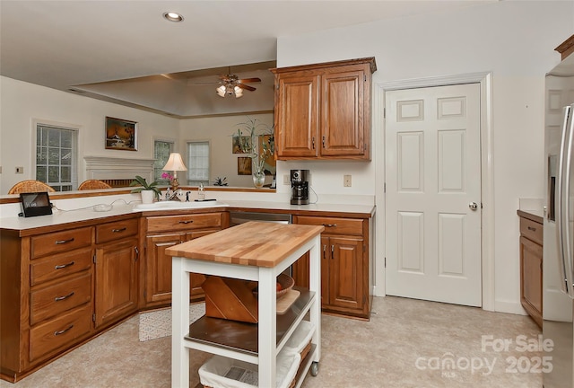 kitchen with ceiling fan, appliances with stainless steel finishes, kitchen peninsula, and sink