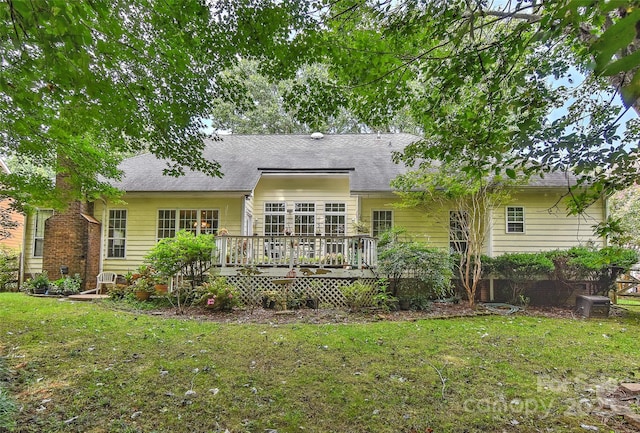 back of property with a wooden deck and a lawn