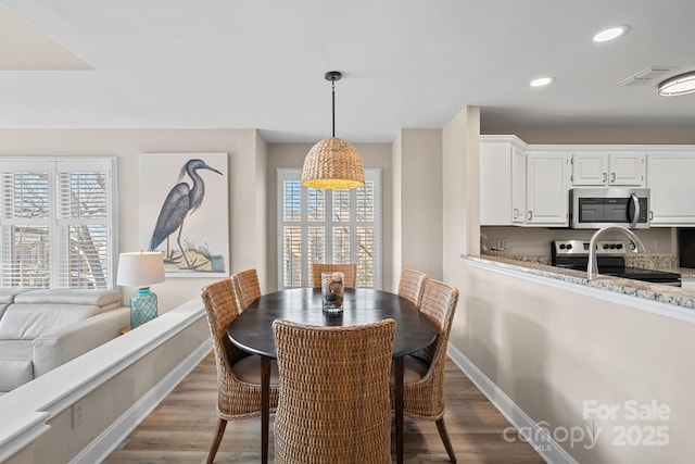 dining room with light hardwood / wood-style flooring and a wealth of natural light