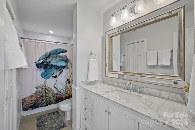 bathroom with tile patterned floors, vanity, toilet, and curtained shower