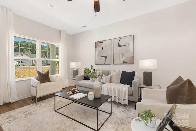 living area with visible vents, ceiling fan, and wood finished floors