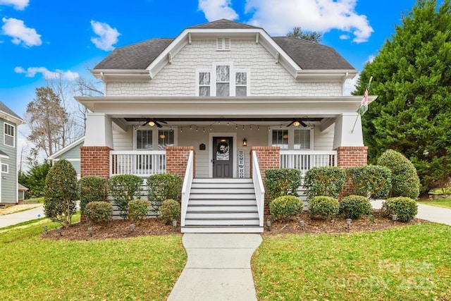 view of front of property featuring covered porch, ceiling fan, and a front lawn