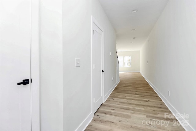 hallway with light hardwood / wood-style floors