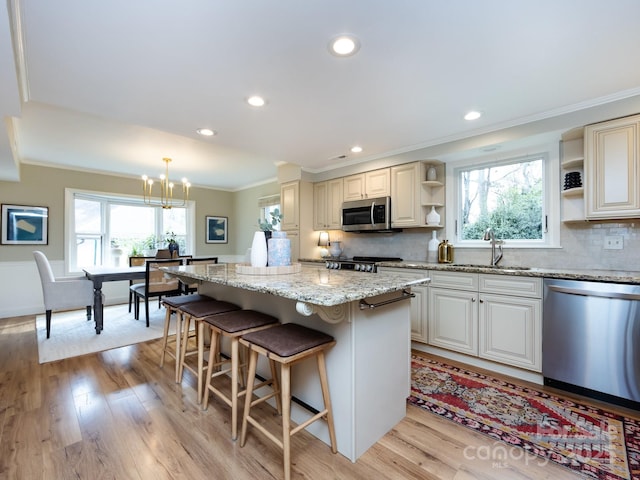 kitchen featuring appliances with stainless steel finishes, a wealth of natural light, a sink, and open shelves