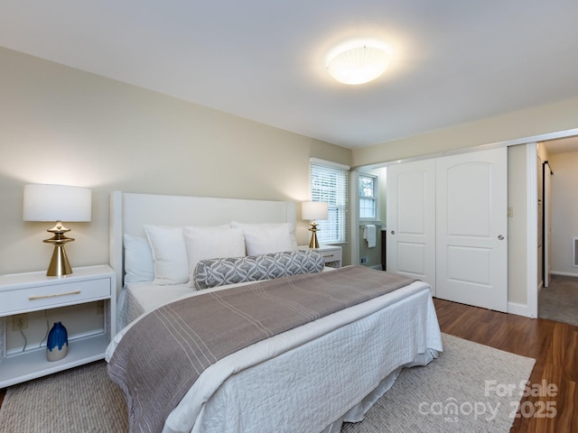 bedroom with a closet, baseboards, and wood finished floors