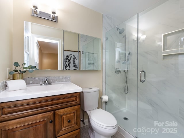 bathroom featuring vanity, a marble finish shower, toilet, and decorative backsplash