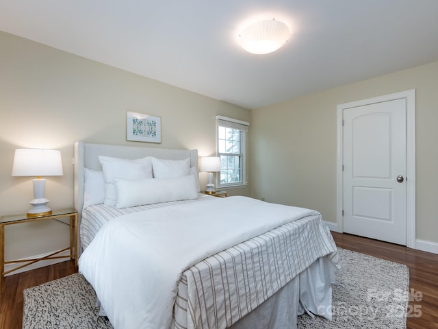 bedroom featuring dark wood-style floors and baseboards