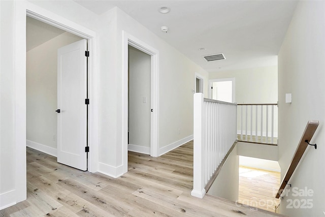 hallway with light hardwood / wood-style floors