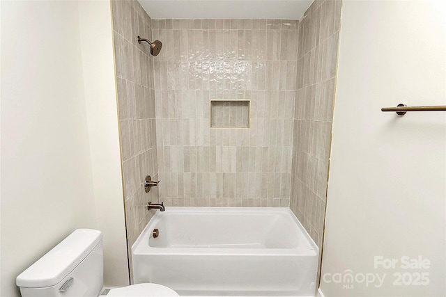 bathroom with tiled shower / bath and toilet