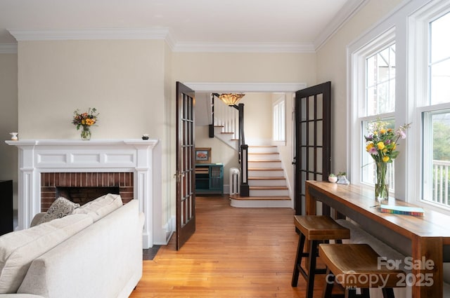 corridor featuring light wood finished floors, stairway, and crown molding