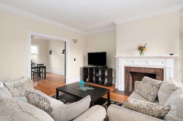 living area with crown molding, wood finished floors, a fireplace, and baseboards