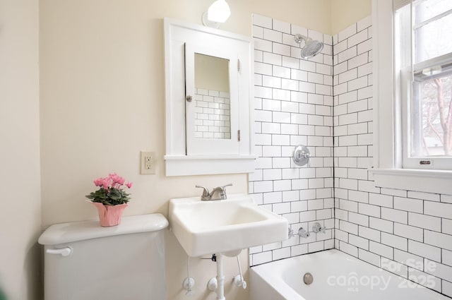 bathroom with bathtub / shower combination, toilet, and a sink