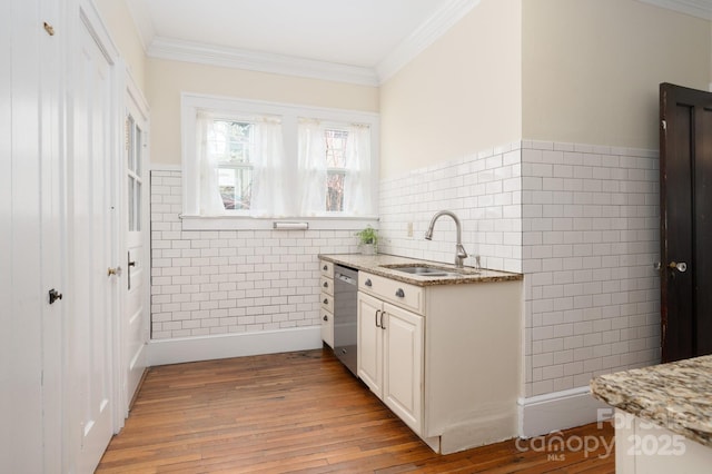 kitchen featuring a sink, crown molding, white cabinets, light wood-type flooring, and dishwasher