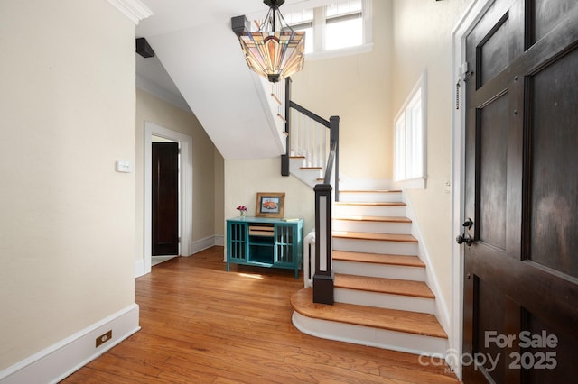 entryway featuring stairs, baseboards, and wood finished floors