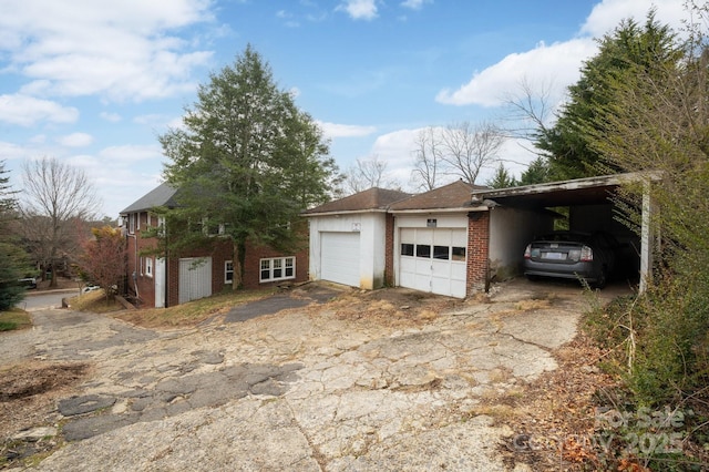 garage featuring driveway and a carport