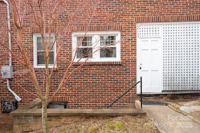 view of exterior entry featuring brick siding