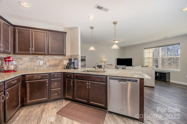 kitchen with pendant lighting, sink, stainless steel dishwasher, dark brown cabinetry, and kitchen peninsula