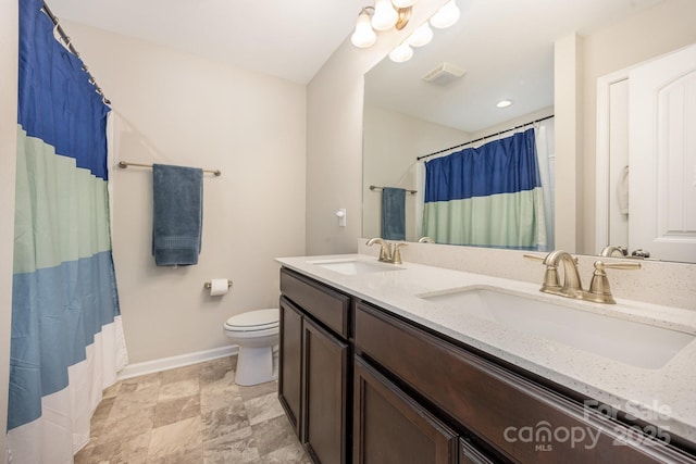 bathroom with vanity, curtained shower, and toilet